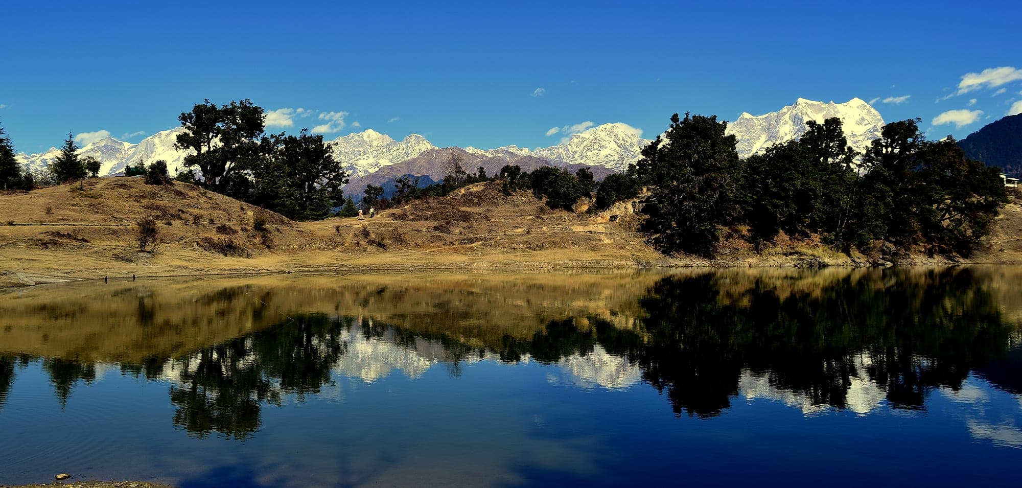 The Himalaya reflected in the still water of Deoria Tal at dawn