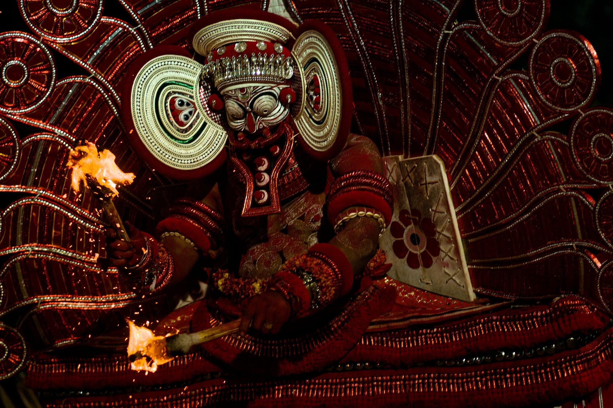 A Theyyam performer in full headdress and costume in Kerala