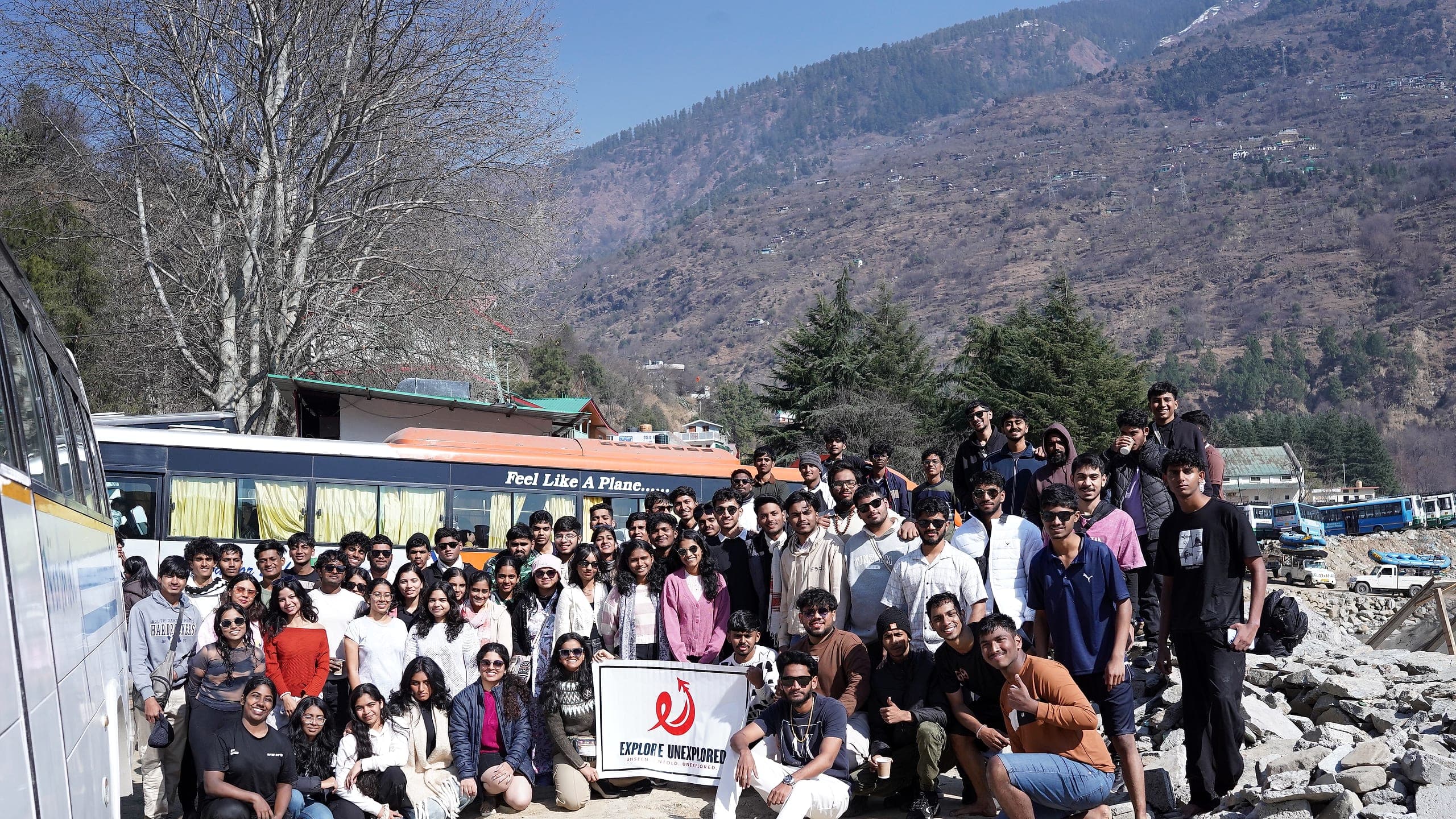 A college batch of around two hundred students with their coaches and an Explore Unexplored banner, on a trip in Himachal Pradesh
