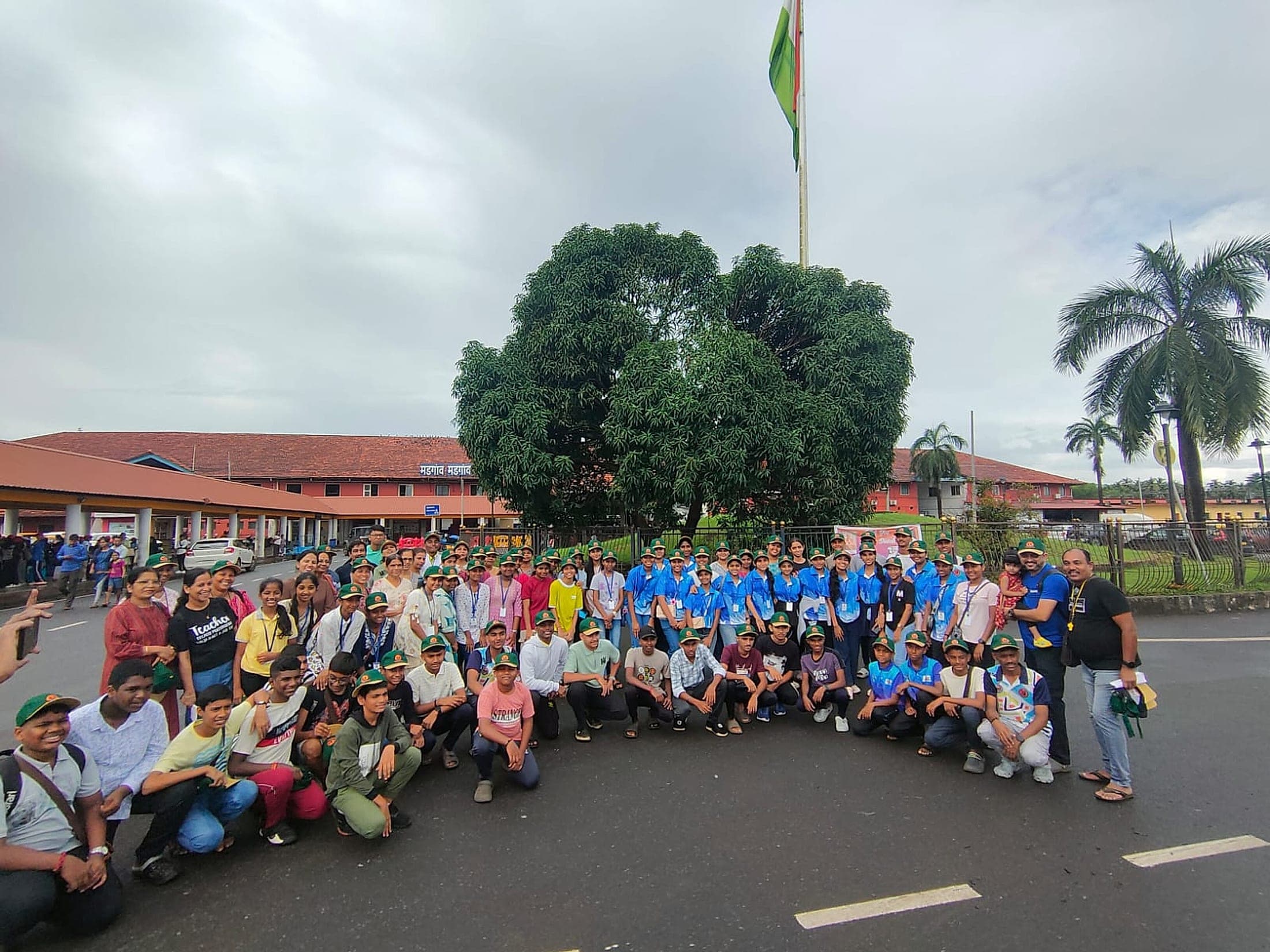A school group in uniform assembled for a photograph beside the flagpole at the start of their tour